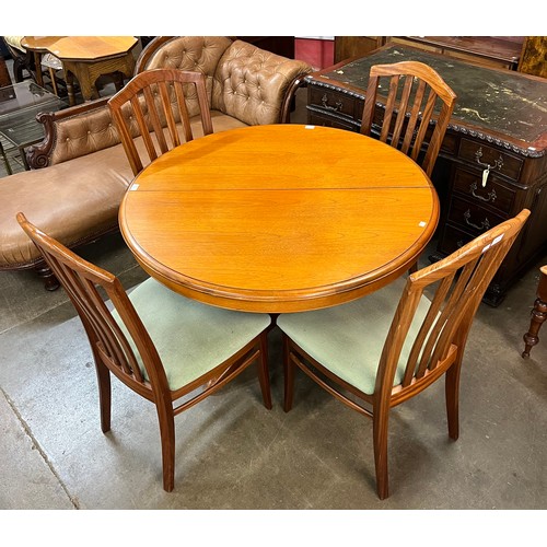 50 - A Stag teak circular extending dining table and four chairs