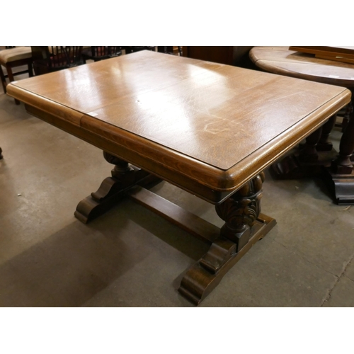 102 - A carved oak extending dining table