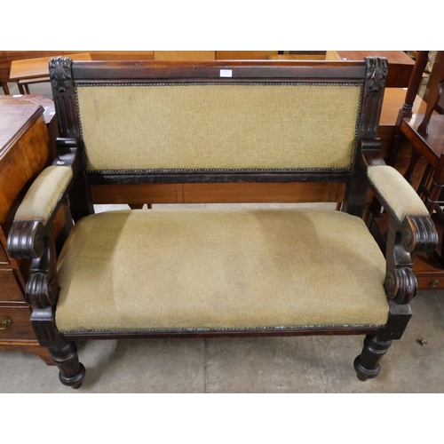 123 - An early 20th Century carved mahogany and fabric upholstered settle