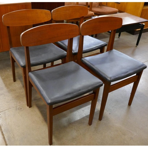 24A - A set of four teak and black vinyl dining chairs