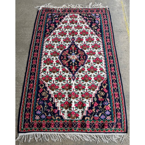 154A - A pink, blue and white floral patterned rug 173 x 110cms