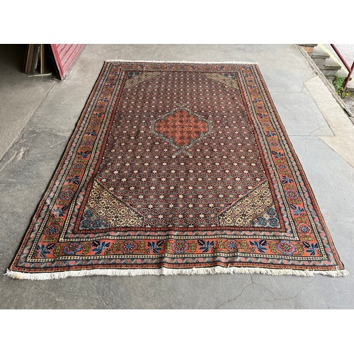 154C - An Eastern terracotta and blue ground rug 295 x 208cms
