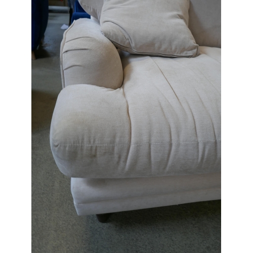 1570 - A cream upholstered three seater sofa - damaged leg - stained