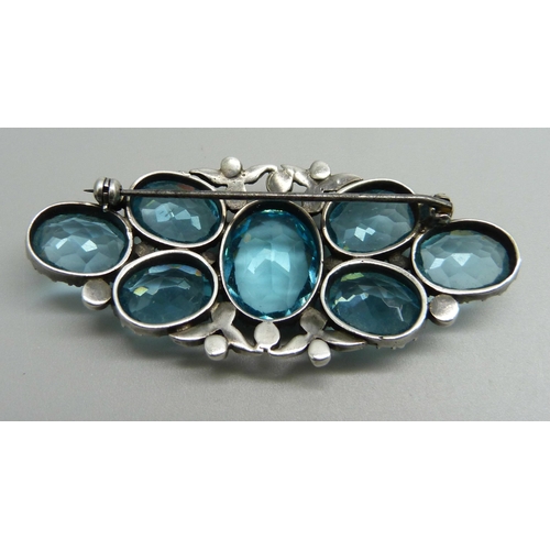 1127 - A white metal early 20th Century brooch with paste stones, tests as silver, 64mm