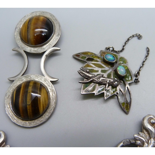 1131 - A silver and tiger's eye pendant, a white metal buckle with continental control mark and a pendant/p... 