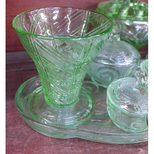 675 - A collection of uranium glass including a flower frog, dressing table set, vases, etc. **PLEASE NOTE... 