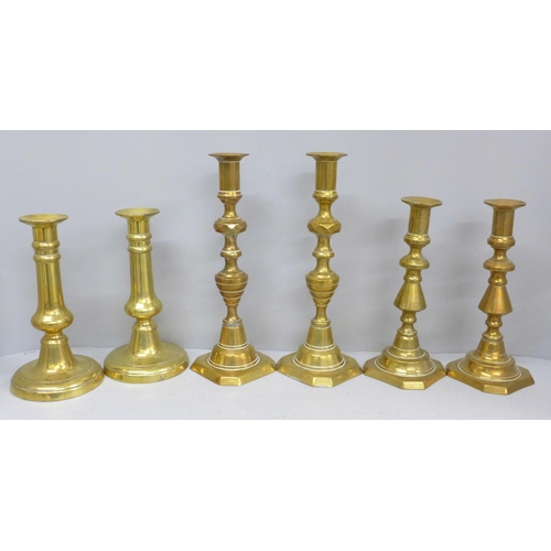 702 - Three pairs of brass candlesticks