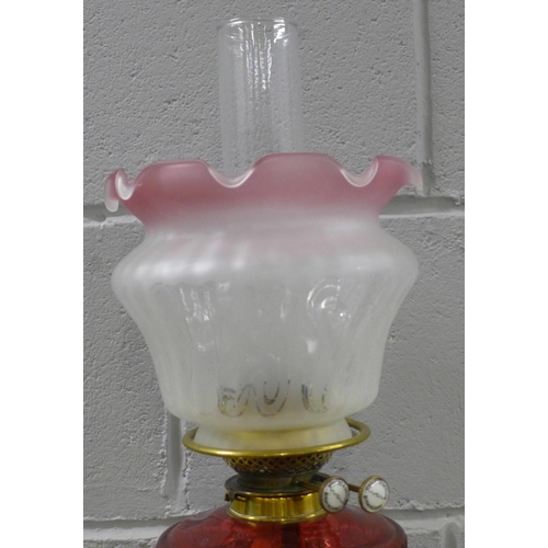 789 - An Art Nouveau brass oil lamp with ruby glass reservoir