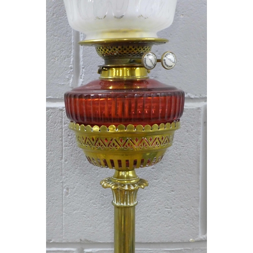 789 - An Art Nouveau brass oil lamp with ruby glass reservoir