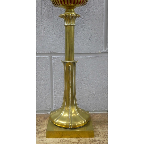 789 - An Art Nouveau brass oil lamp with ruby glass reservoir