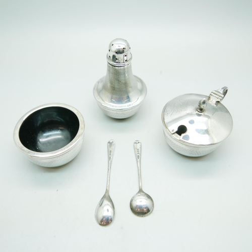 829 - A silver Art Deco condiment set, Birmingham 1935, with two silver spoons, total weight with liners 1... 