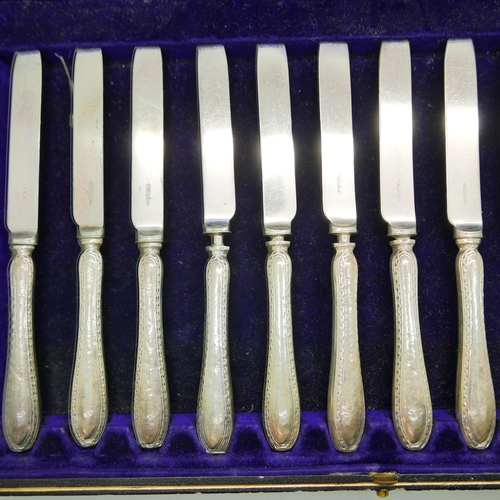 835 - A cased set of twelve dessert knives, with silver covered handles