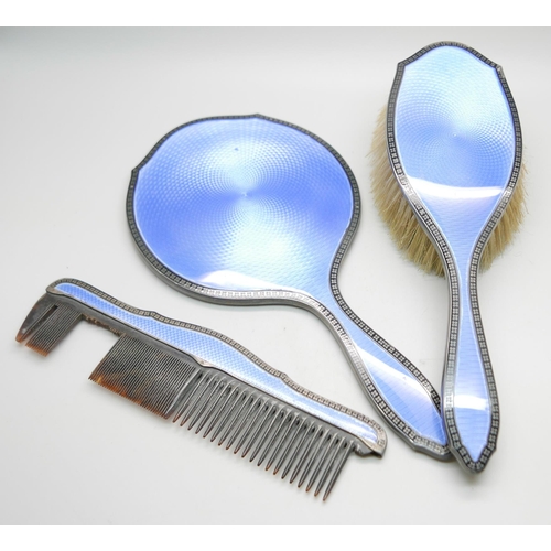 852 - A silver and blue enamelled hand mirror with black enamelled border and with matching brush and comb... 