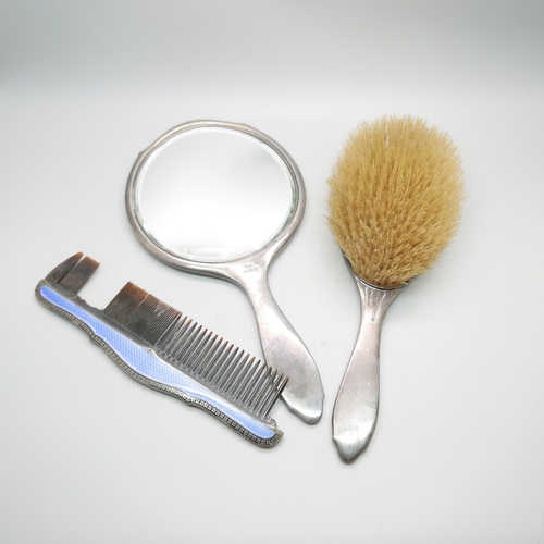 852 - A silver and blue enamelled hand mirror with black enamelled border and with matching brush and comb... 