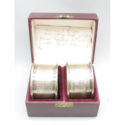 869 - A boxed pair of silver napkin rings, 27g