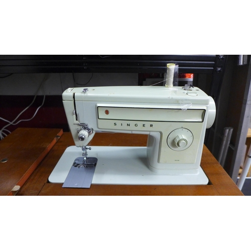 2144 - A Singer 509 240v sewing machine with pedal in an integrated work table