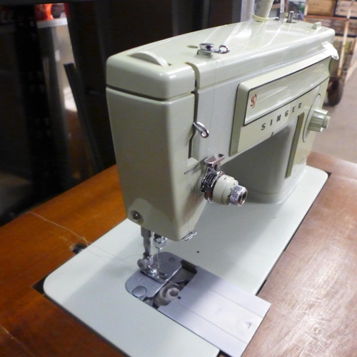 2144 - A Singer 509 240v sewing machine with pedal in an integrated work table