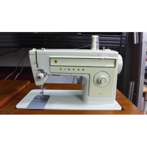 2144 - A Singer 509 240v sewing machine with pedal in an integrated work table