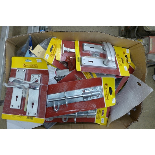 2361 - A box of door furniture, most sealed in packets, handles, knobs, etc.