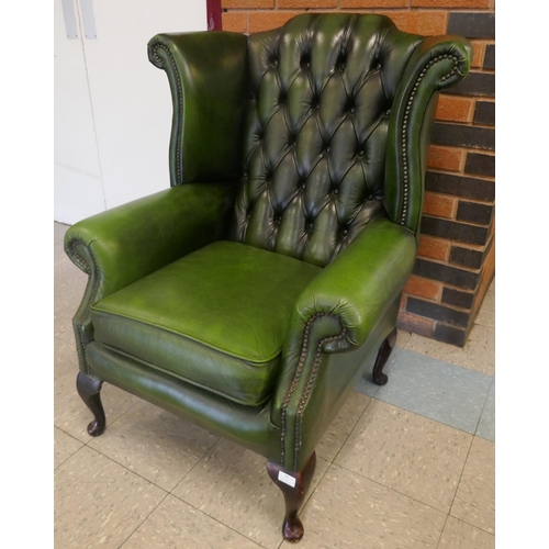 99 - A green leather Chesterfield wingback armchair