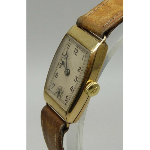 1005 - A 9ct gold tonneau cased Art Deco wristwatch with leather strap, 21mm case