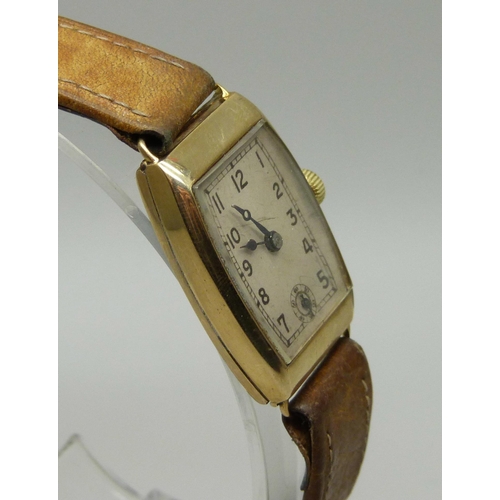 1005 - A 9ct gold tonneau cased Art Deco wristwatch with leather strap, 21mm case