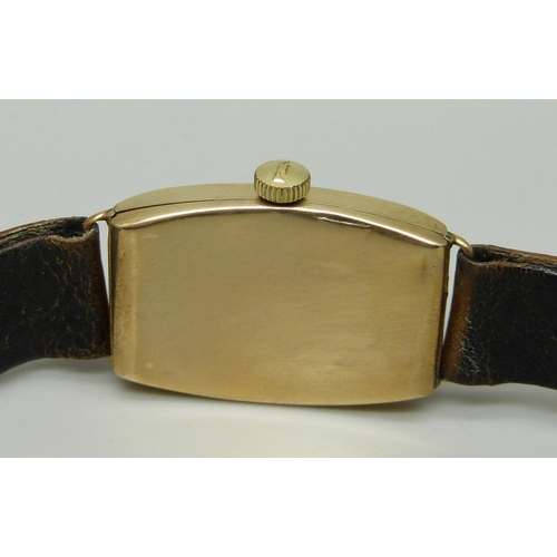 1005 - A 9ct gold tonneau cased Art Deco wristwatch with leather strap, 21mm case