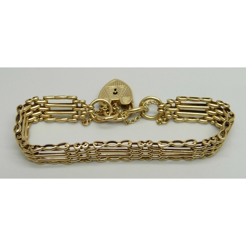 1021 - A 9ct yellow gold gate bracelet with engraved padlock clasp and safety chain, 19cm, 20.6g