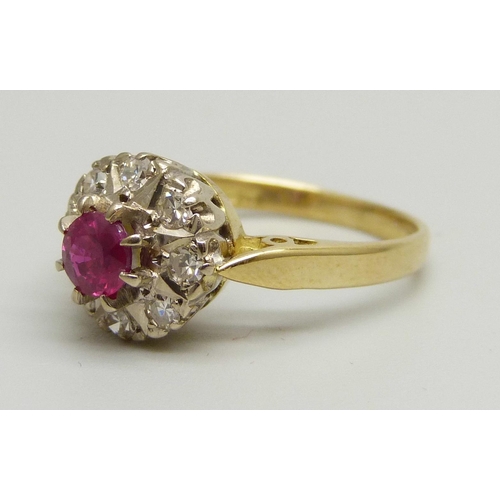 1023 - An 18ct yellow gold cluster ring set with eight round brilliant cut diamonds (2mm) and a central rub... 