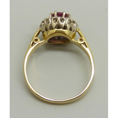 1023 - An 18ct yellow gold cluster ring set with eight round brilliant cut diamonds (2mm) and a central rub... 