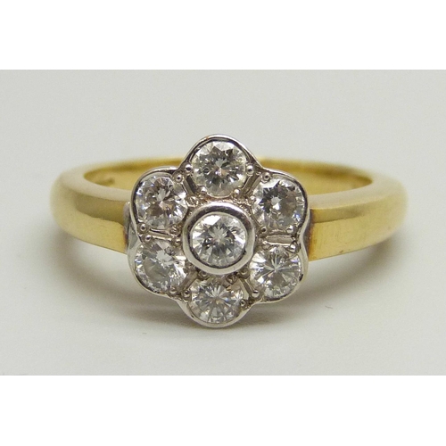 1026 - An 18ct yellow gold daisy cluster ring set with seven round brilliant cut diamonds, approximately 0.... 