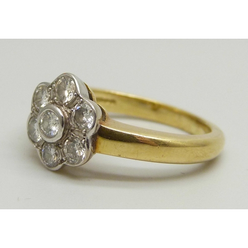 1026 - An 18ct yellow gold daisy cluster ring set with seven round brilliant cut diamonds, approximately 0.... 