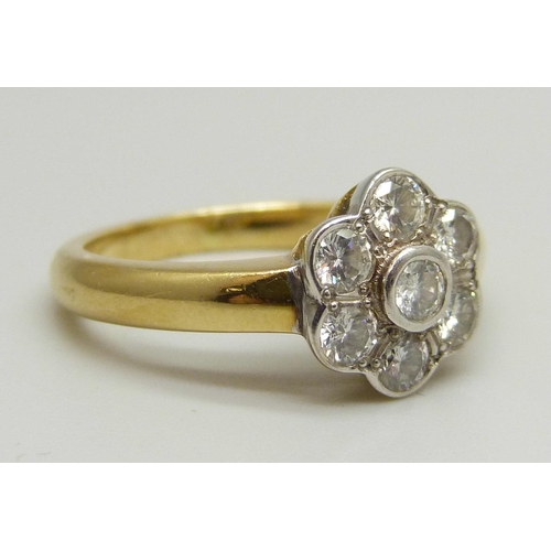 1026 - An 18ct yellow gold daisy cluster ring set with seven round brilliant cut diamonds, approximately 0.... 