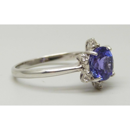 1035 - An 18ct white gold ring set with a round AAA grade tanzanite and six small round facet cut diamonds,... 