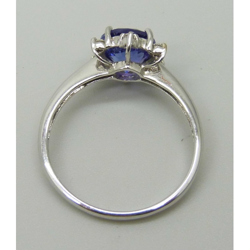 1035 - An 18ct white gold ring set with a round AAA grade tanzanite and six small round facet cut diamonds,... 