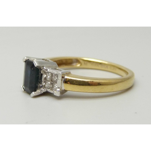 1040 - An 18ct yellow gold ring set with a central sapphire (6 x 4mm) and four princess cut diamond on each... 