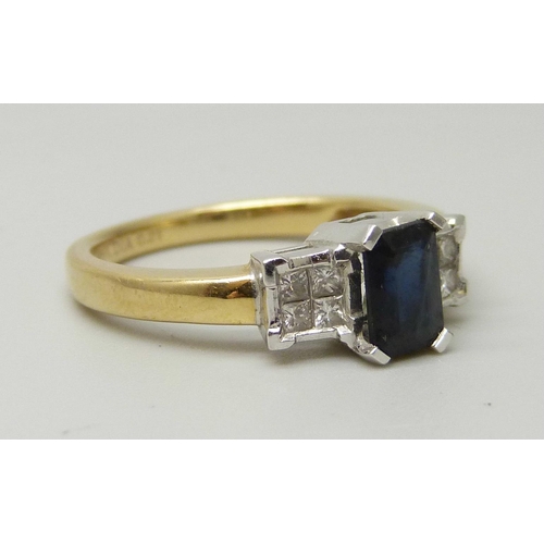 1040 - An 18ct yellow gold ring set with a central sapphire (6 x 4mm) and four princess cut diamond on each... 