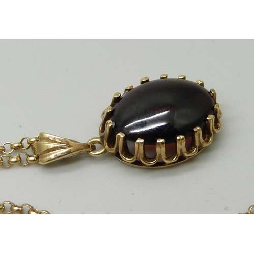 1043 - A 9ct yellow gold pendant set with a cabochon cut garnet, on a 9ct gold fine round belcher link chai... 