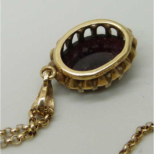 1043 - A 9ct yellow gold pendant set with a cabochon cut garnet, on a 9ct gold fine round belcher link chai... 