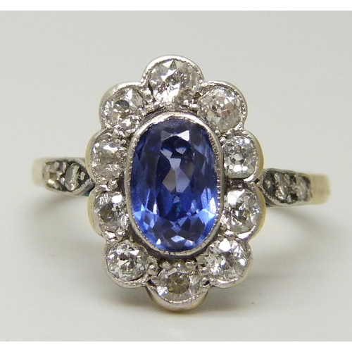 1076 - An 18ct gold, oval sapphire and diamond cluster ring, oval centre light blue sapphire measuring appr... 