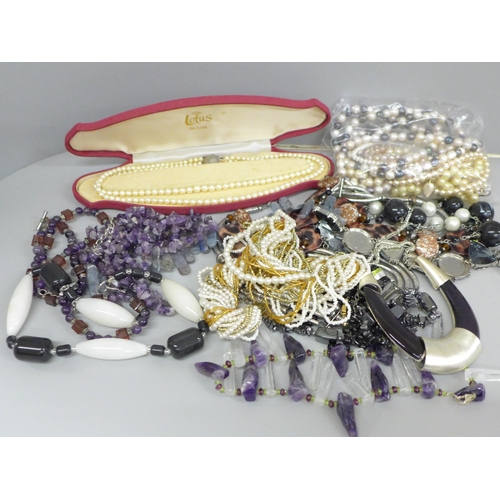 710 - A collection of costume jewellery including gemstones, pearls with a silver clasp, etc.