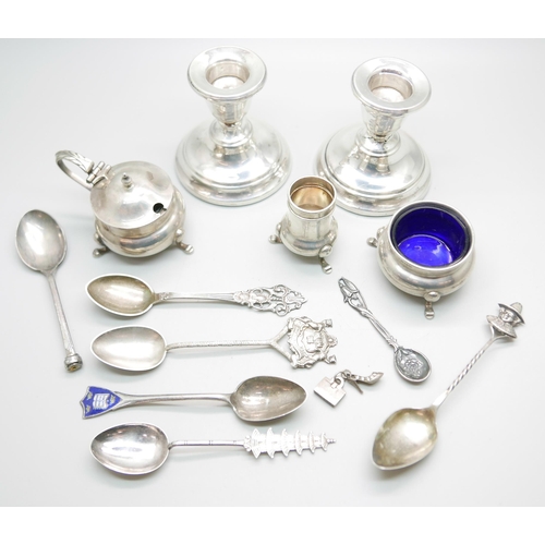 883 - A collection of silver including a pair of candlesticks, condiments, spoons, etc., 137g of weighable... 