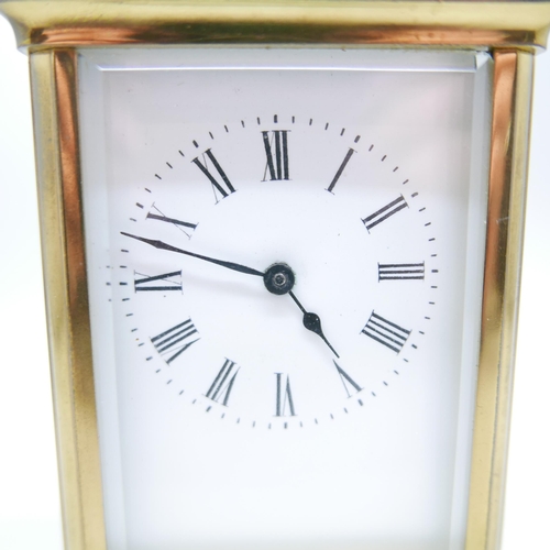 884 - A brass and glass sided carriage clock