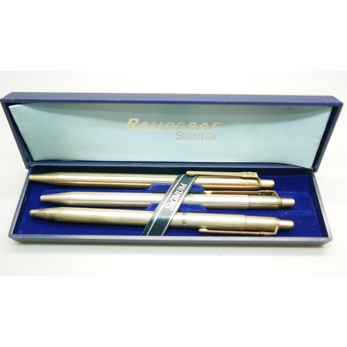 910 - Three signum ballpoint pens; two 925 silver and one rolled-gold, with one Signum box