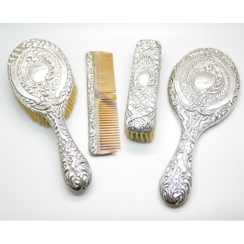 923 - A four piece silver dressing table set, Birmingham 1906, a mirror, hand brush , hair brush and cloth... 