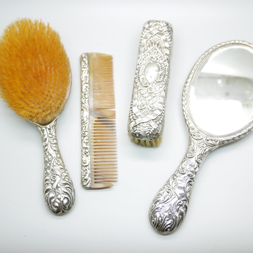 923 - A four piece silver dressing table set, Birmingham 1906, a mirror, hand brush , hair brush and cloth... 