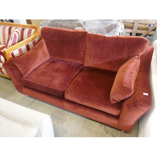 1505 - A rust velvet three seater sofa