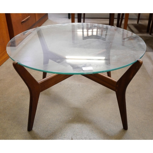 25 - A teak and glass topped circular coffee table