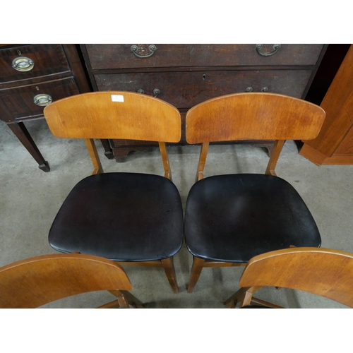 42 - A set of four teak and black vinyl chairs