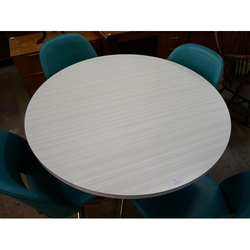 54 - A chrome and Formica circular dining table and four teal vinyl chairs